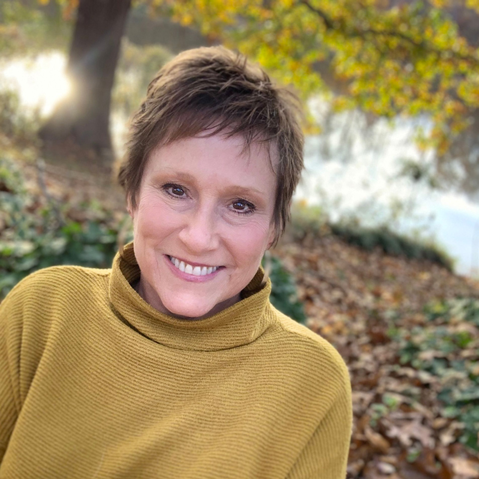 photo of Lisa Kipps-Brown lying in fall leaves