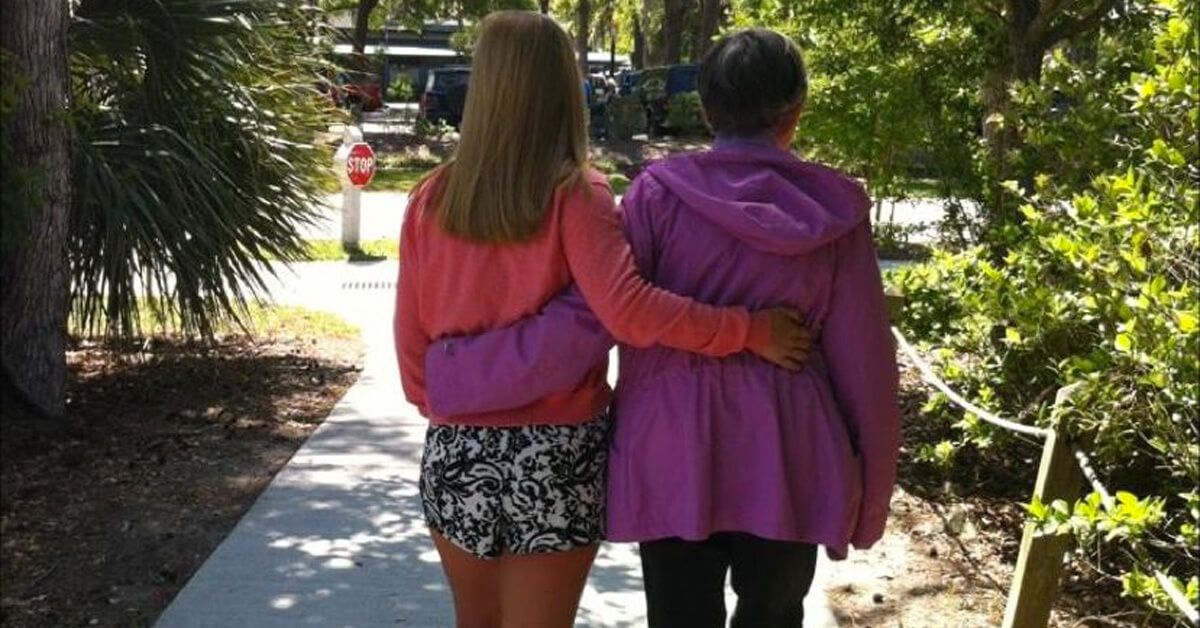 photo of elderly woman with dementia walking with her granddaughter